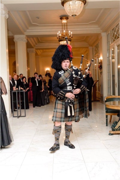 Playing bagpipes in full Highland Dress at a formal event